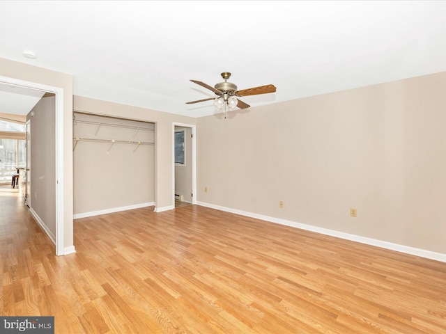 unfurnished bedroom featuring ceiling fan, a baseboard heating unit, a closet, and light wood-type flooring