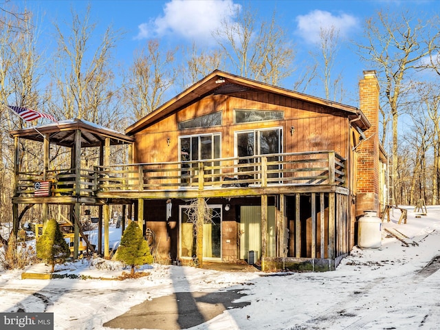 snow covered property with a deck