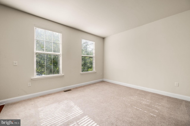 unfurnished room featuring light carpet