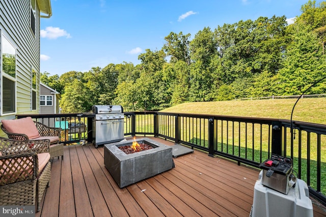 wooden deck with a lawn, grilling area, and an outdoor fire pit