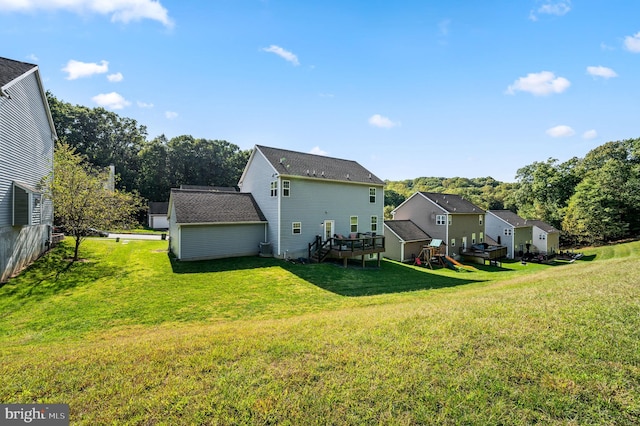 rear view of house featuring a wooden deck and a yard