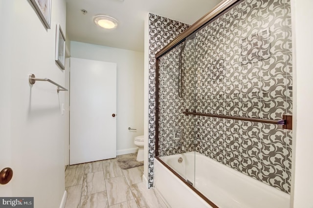 bathroom with toilet and combined bath / shower with glass door