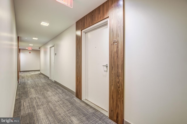 hallway featuring dark colored carpet