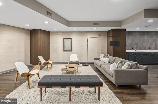 living room with dark hardwood / wood-style floors and sink