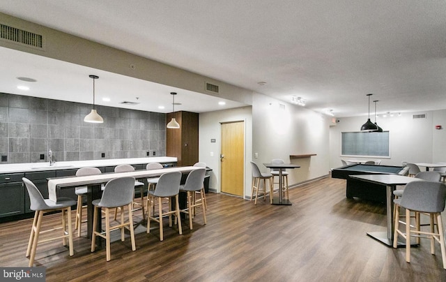 interior space with wet bar, a textured ceiling, tile walls, and dark hardwood / wood-style flooring