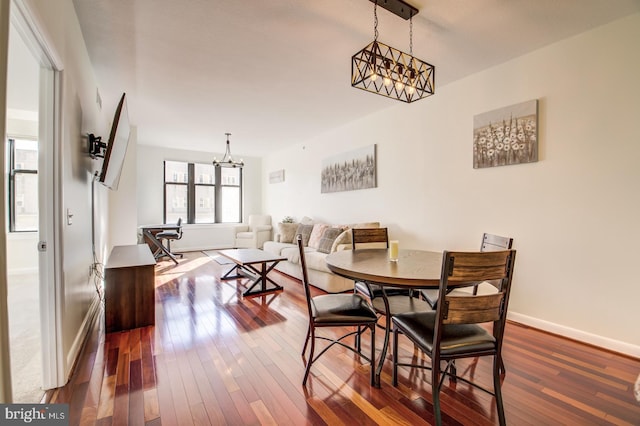 dining space with a notable chandelier and wood-type flooring