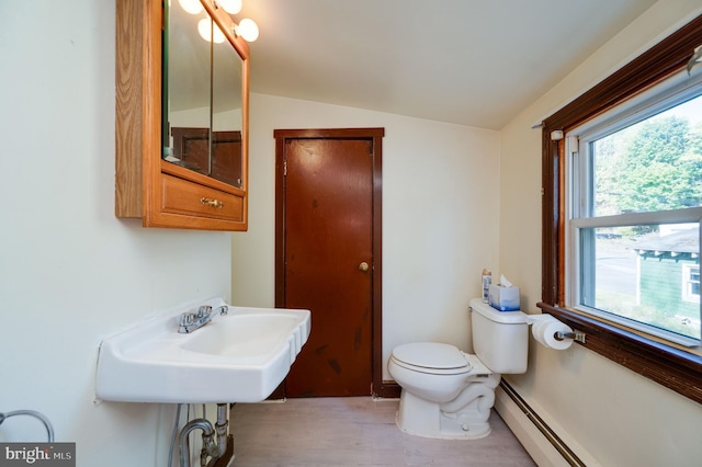 bathroom with hardwood / wood-style floors, vaulted ceiling, toilet, and a baseboard radiator