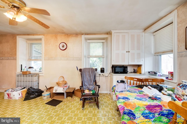 interior space with multiple windows and ceiling fan