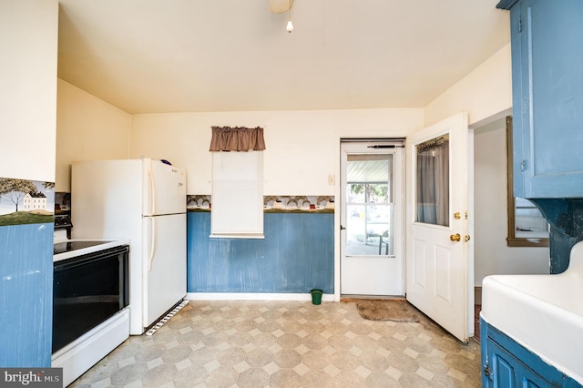 kitchen with white range with electric stovetop and blue cabinetry