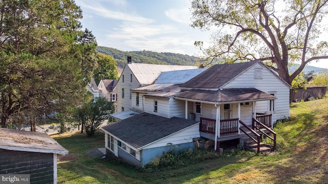 exterior space with a yard, a mountain view, and covered porch