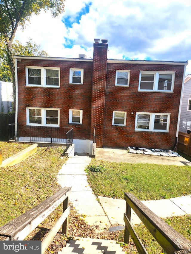 3839 1st St SE, Washington, DC 20032 - view of front of home with a chimney, a front yard, a patio, and brick siding