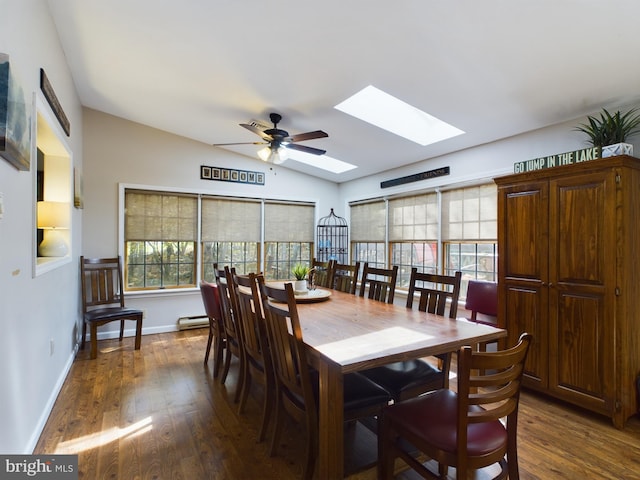 dining space featuring ceiling fan, baseboard heating, lofted ceiling with skylight, and dark hardwood / wood-style flooring