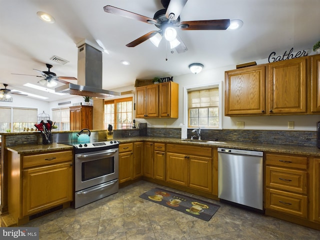 kitchen featuring stainless steel appliances, island range hood, a wealth of natural light, and sink