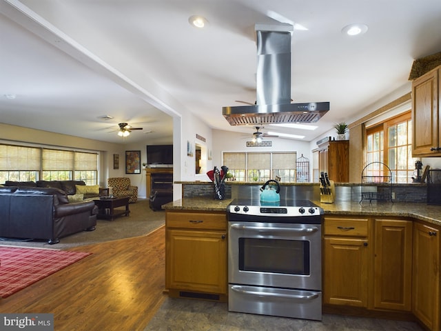 kitchen with ceiling fan, island range hood, dark wood-type flooring, electric range, and dark stone countertops