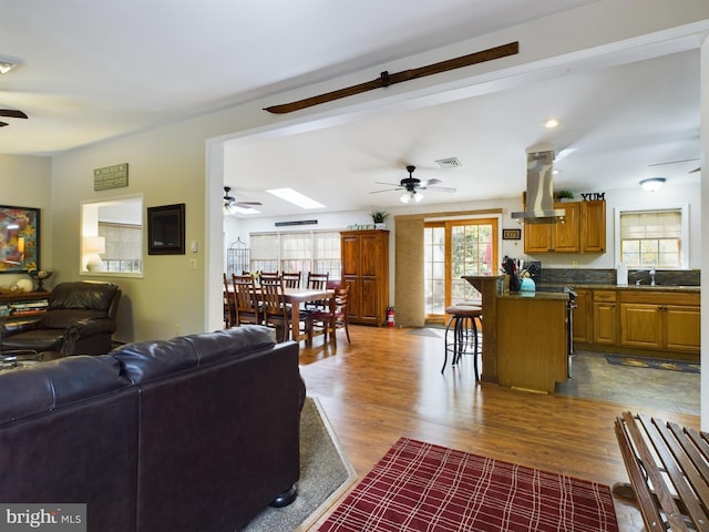 living room with a skylight, hardwood / wood-style flooring, and sink