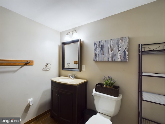 bathroom with hardwood / wood-style floors, vanity, and toilet