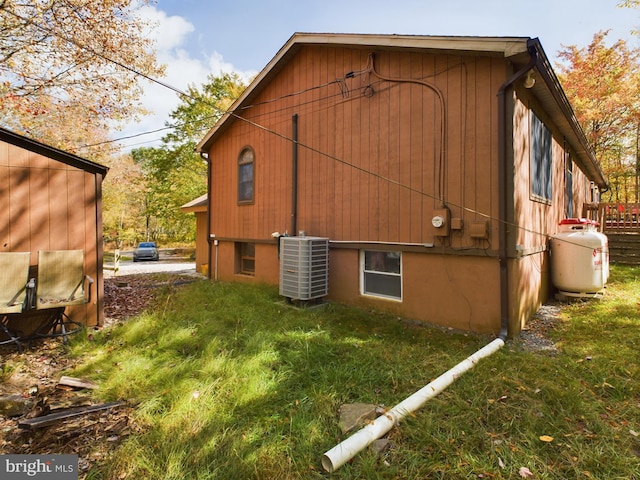 view of home's exterior with a lawn and central air condition unit