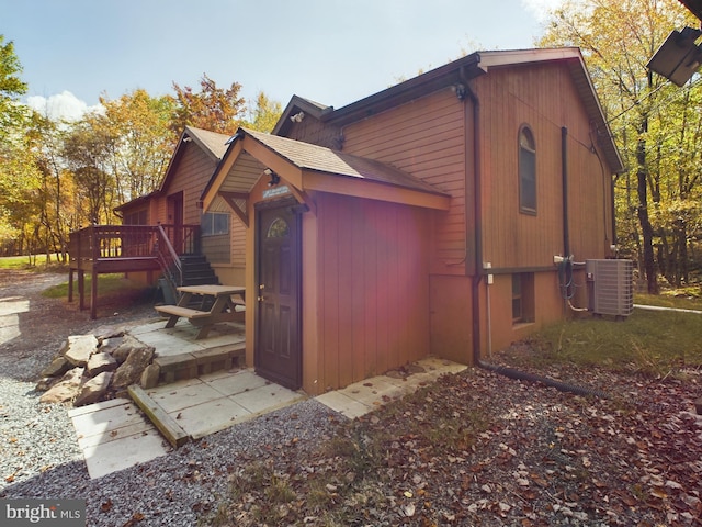 view of property exterior with cooling unit, a patio area, and a deck