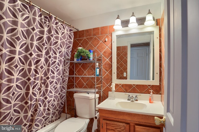 bathroom with tile walls, vanity, toilet, and a shower with curtain