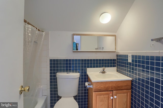 full bathroom with shower / bath combo, lofted ceiling, toilet, tile walls, and vanity