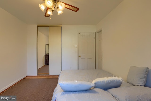 carpeted bedroom with ceiling fan and a closet