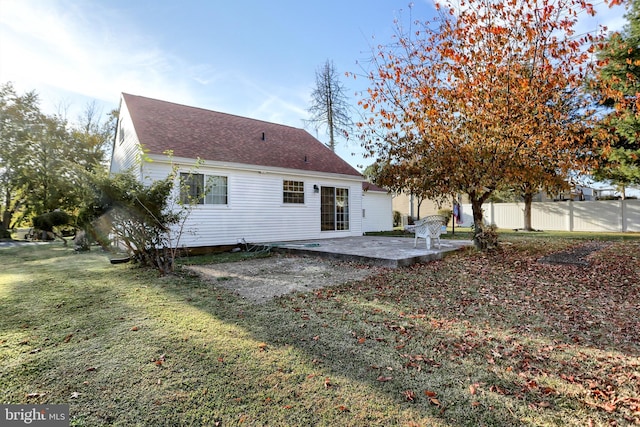 rear view of property featuring a lawn and a patio