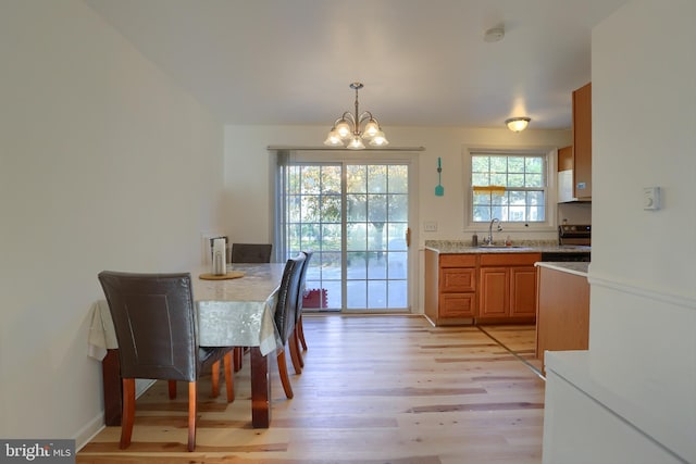 dining room with light hardwood / wood-style flooring, a notable chandelier, and sink