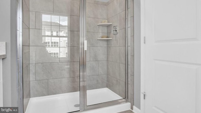 bathroom featuring a shower with door