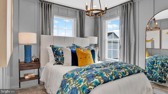 carpeted bedroom featuring a chandelier