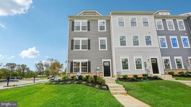 townhome / multi-family property featuring a front yard