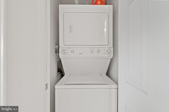 clothes washing area featuring stacked washer / dryer