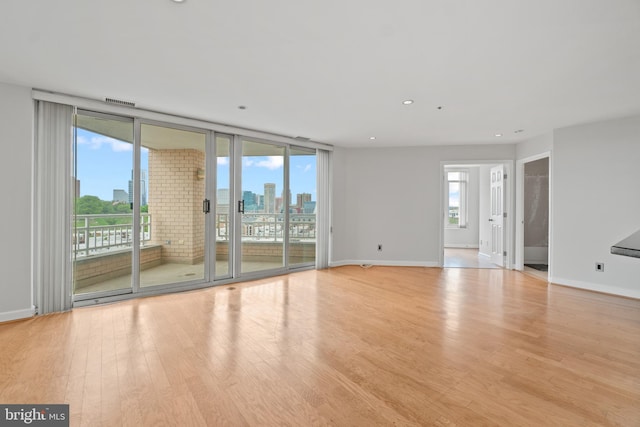 unfurnished room featuring light wood-type flooring and expansive windows