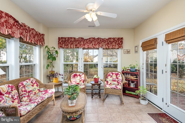 sunroom featuring ceiling fan and a baseboard heating unit