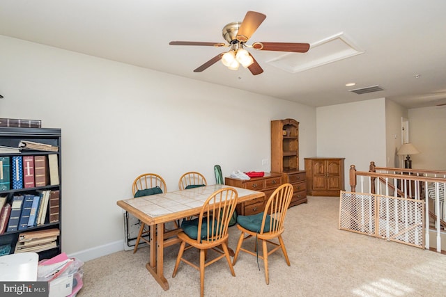 carpeted dining space with ceiling fan