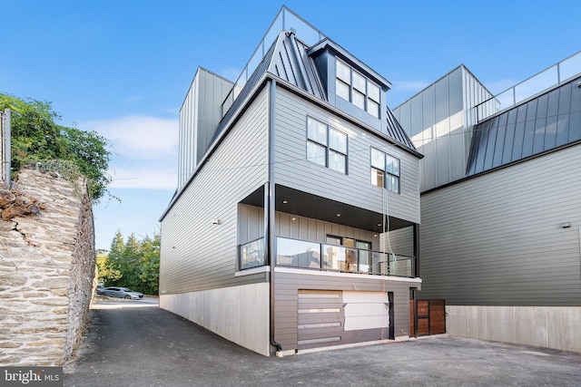 view of front of home featuring a garage and a balcony