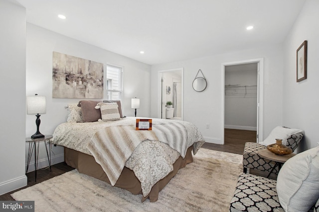 bedroom featuring a walk in closet, dark hardwood / wood-style floors, and a closet