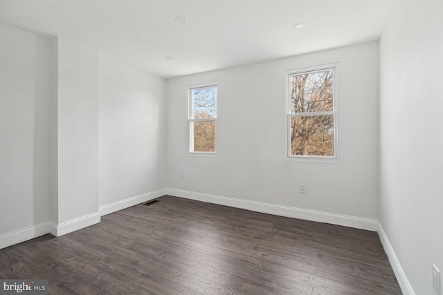 unfurnished room with dark hardwood / wood-style floors and plenty of natural light