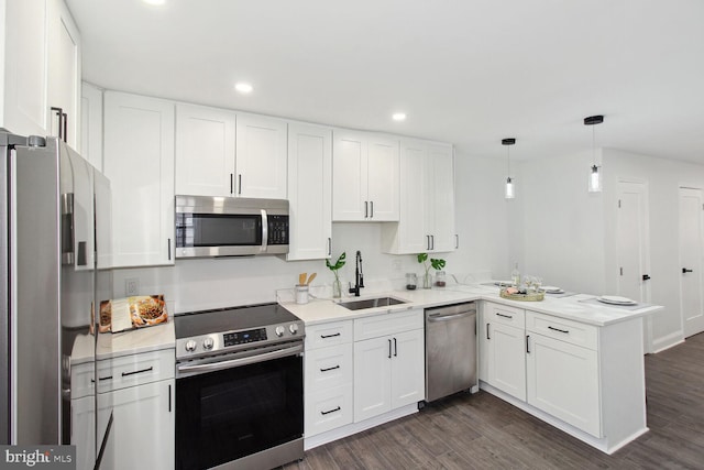 kitchen with white cabinetry, stainless steel appliances, dark wood-type flooring, and kitchen peninsula