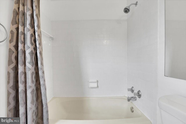 bathroom with shower / bathtub combination with curtain and toilet