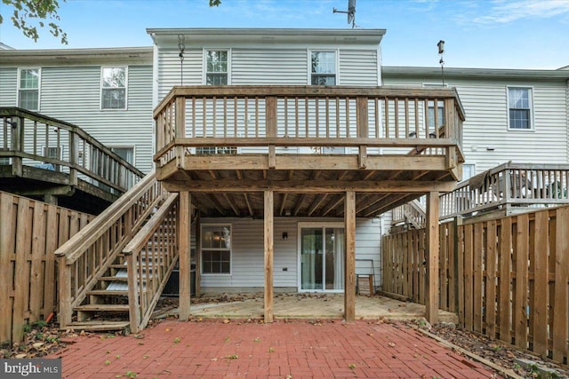 rear view of property featuring a patio and a deck