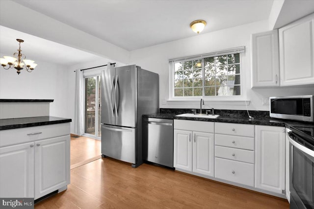 kitchen featuring light hardwood / wood-style flooring, appliances with stainless steel finishes, sink, and white cabinetry