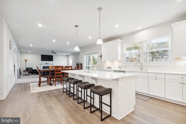 kitchen with a wealth of natural light, white cabinetry, and a center island