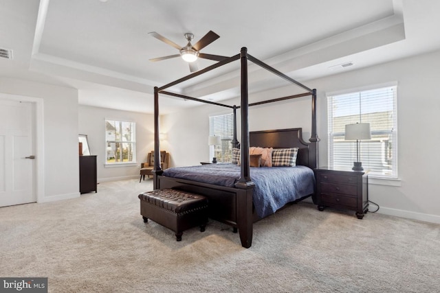 bedroom with ceiling fan, light colored carpet, and multiple windows