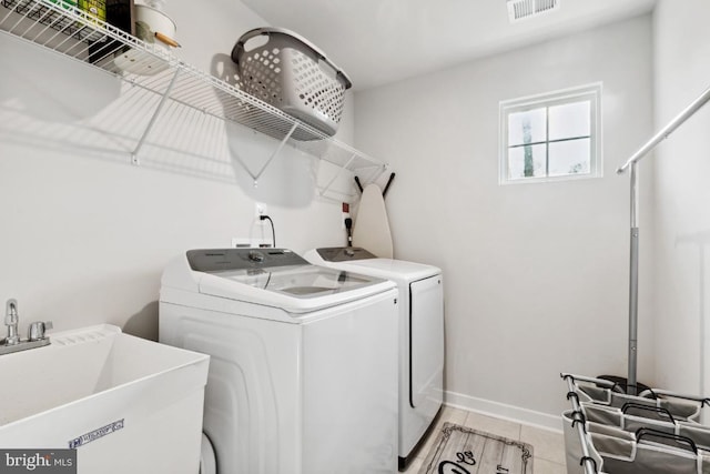 laundry area with washing machine and clothes dryer and sink