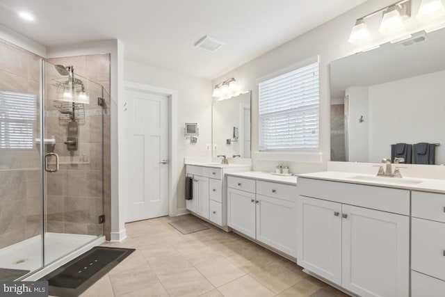 bathroom with walk in shower, vanity, and tile patterned floors