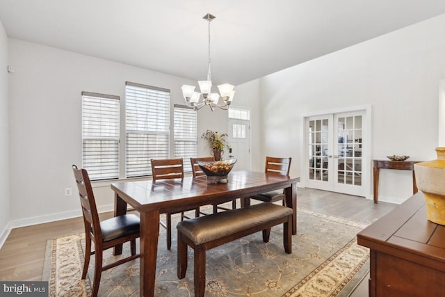 dining area featuring an inviting chandelier, french doors, and hardwood / wood-style flooring