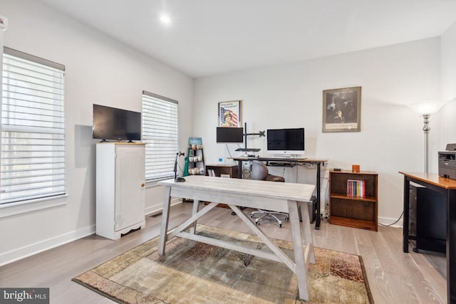 office space with light wood-type flooring and a healthy amount of sunlight