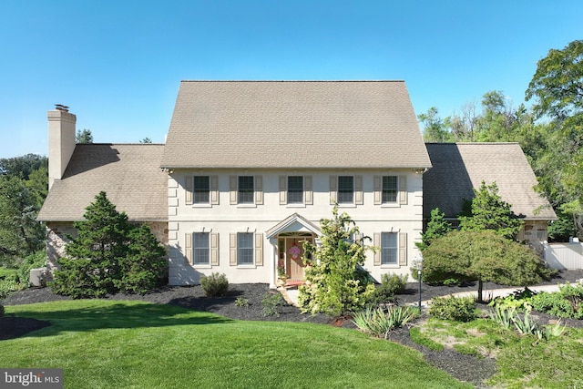 colonial-style house with a front lawn