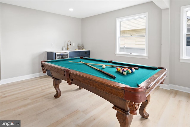 recreation room featuring pool table, bar, and light hardwood / wood-style flooring