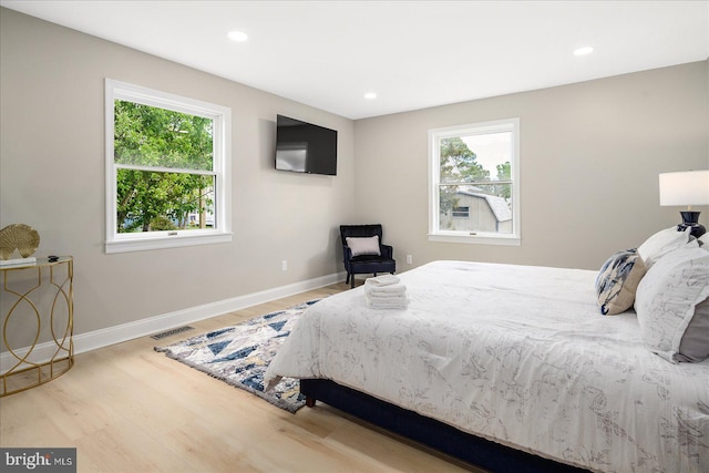 bedroom with hardwood / wood-style flooring and multiple windows